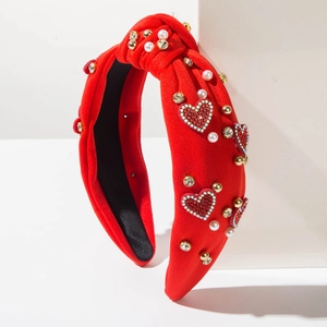 Dettaglio della fascia annodata rossa con cuori di strass e perle sintetiche