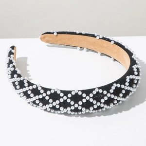Detailed close-up of the pearl grid pattern on a stylish black velvet wide headband
