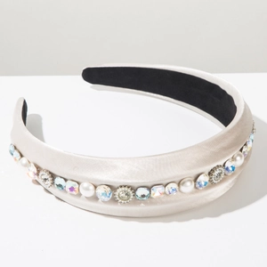 Detailed close-up of champagne satin headband with pearls, crystals, and vintage floral accents