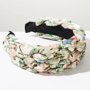 Detail of light green floral braided headband featuring a twist design and thick fabric texture