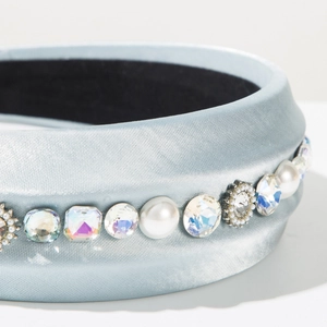Macro shot of light blue satin headband with sparkling rhinestones and white pearls