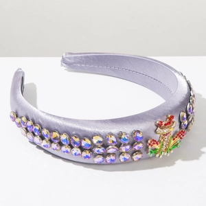 Macro detail of purple satin headband featuring sparkling rhinestones and frog ornament