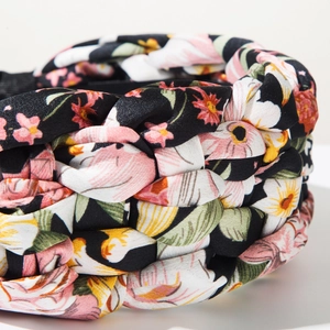 Detailed close-up of the braided floral headband with black fabric and colorful print
