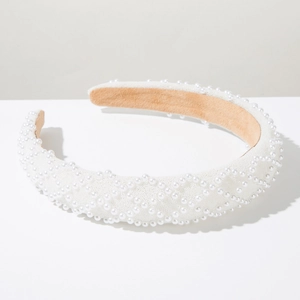 Detailed view of luxury white wide headband with hand-stitched pearls in geometric patterns