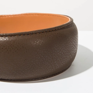 Macro detail of lychee grain brown leather headband with fine orange stitching