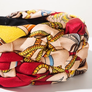 Detailed macro view of woven wide braided headband with retro bohemian silk patterns