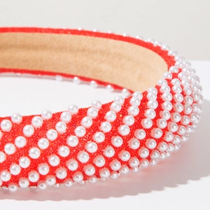 Detailed close-up of red thick pearl headband with luxurious handcrafted fabric texture