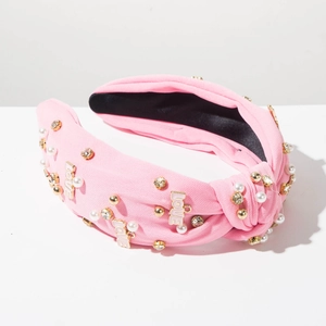 Dettaglio della fascia rosa annodata con lettere LOVE di strass e perle bianche