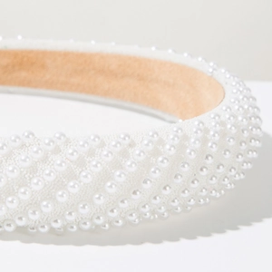 Macro detail of wide pearl headband featuring white hand-set pearls in quilted pattern