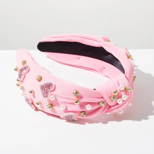 Dettaglio della fascia rosa con strass, motivo a cuore e perle applicate