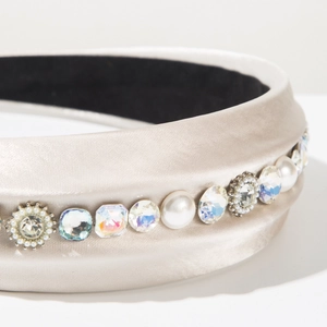 Detailed close-up of champagne satin headband featuring rhinestones and faux pearls