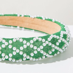 Macro detail of emerald green beadwork and faux pearls on the luxury wide headband