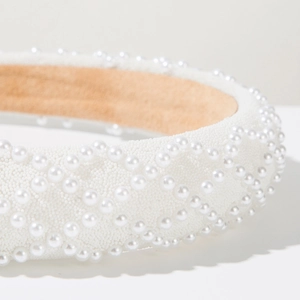 Detail of white wide headband with faux pearls and micro-bead diamond lattice pattern