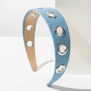 Fashionable denim wide headband with silver metal eyelets on a clean minimalist background