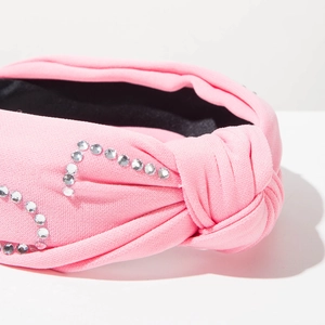 Détail du bandeau rose noué orné de strass argentés et de perles de haute qualité