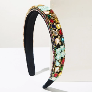 Detail view of baroque velvet headband with colorful rhinestones on a white stand
