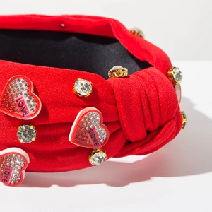 Dettaglio macro della fascia rossa in maglia con strass a forma di cuore