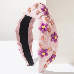 Détail du serre-tête en tissu à carreaux rose et bleu avec fleurs et pierres roses