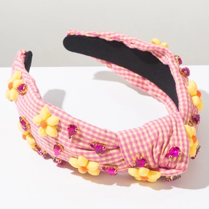 Détail d'un serre-tête en tissu noué avec motif à carreaux jaunes et cristaux roses