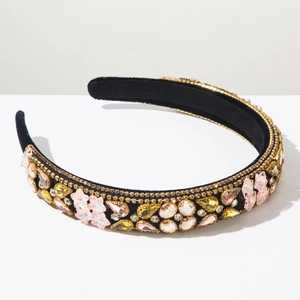 Detailed close-up of Baroque headband with pink crystals and gold bead edges on velvet