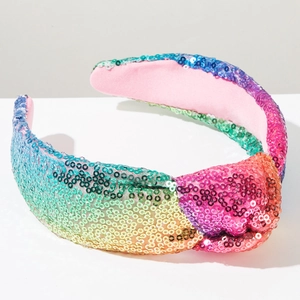 Dettaglio del cerchietto annodato con paillettes arcobaleno e finitura scintillante