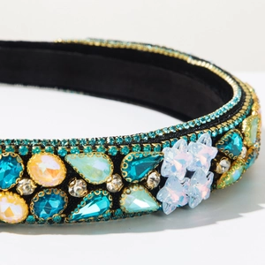 Detail of baroque headband with blue and green rhinestones on black velvet fabric