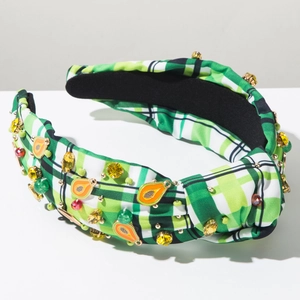 Detailed view of checkered headband with rhinestones and orange papaya charms