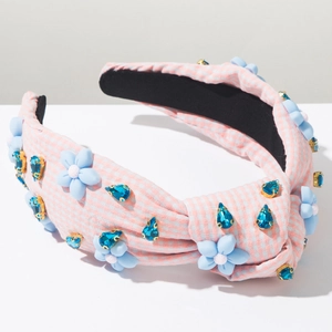 Détail du serre-tête en tissu vichy rose avec fleurs 3D bleues et cristaux brillants