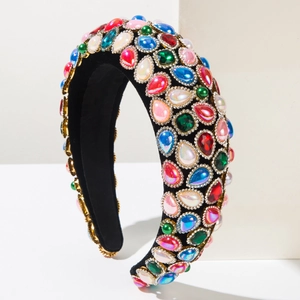Dettaglio del cerchietto imbottito barocco con strass colorati e finiture dorate