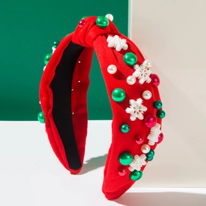 Gros plan d'un serre-tête de Noël rouge avec des perles et des breloques de flocons de neige