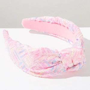Dettaglio del cerchietto con paillettes rosa con nodo superiore e morbida fodera in velluto