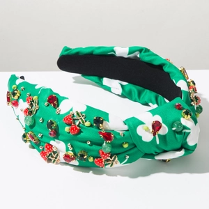 Detail of green knot headband with red strawberry crystal beads and gold metal accents