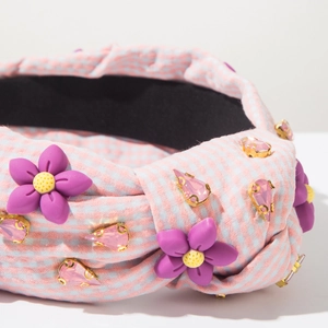 Macro d'un serre-tête en tissu à carreaux roses avec fleurs mauves et détails gemmes