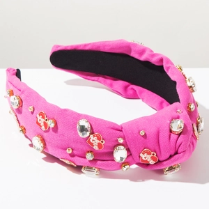 Macro detail of wide pink knotted headband with rhinestones and Love heart charms