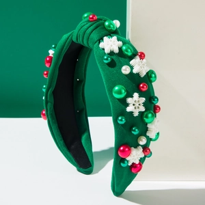 Gros plan d'un serre-tête vert à nœud avec flocons de Noël et perles décoratives