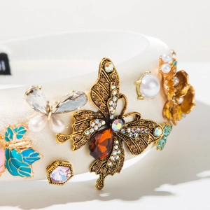 Detail of baroque headband featuring bronze butterflies, red crystals and imitation pearls