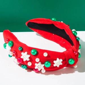 Détail d'un serre-tête de Noël rouge avec perles, flocons de neige et texture de tissu noué