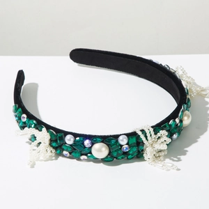 Detailed close-up of Baroque velvet headband with green rhinestones and pearls