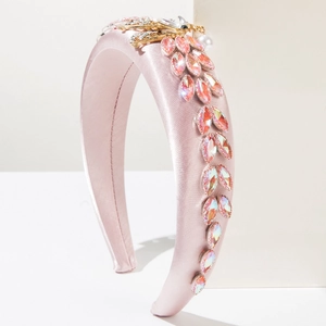 Detail of pink silk satin headband with rhinestone feathers and gold insect accent