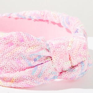Dettaglio del cerchietto rosa con paillettes, nodo centrale e texture lucida e brillante