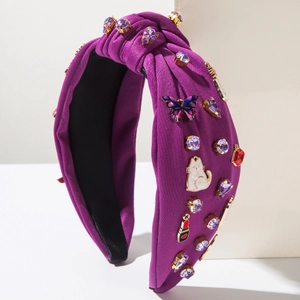 Détail d'un bandeau violet avec nœud, strass et breloques colorées