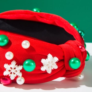 Gros plan d'un serre-tête de Noël rouge avec perles et breloques flocon de neige