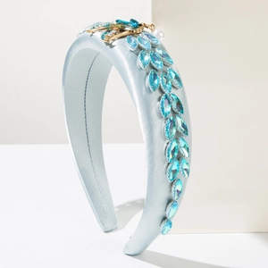 Detail of light blue satin headband with marquise rhinestones and gold insect accent