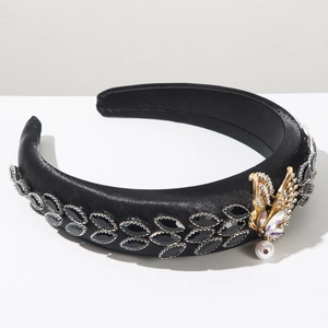 Detail of black satin headband with leaf rhinestones, golden butterfly and white pearl