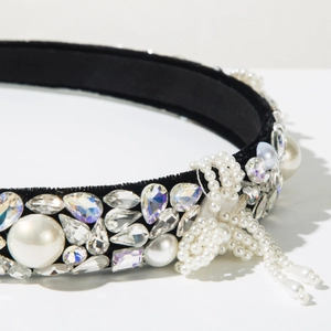 Macro shot of baroque headband with rhinestones, velvet base, and woven pearl bows