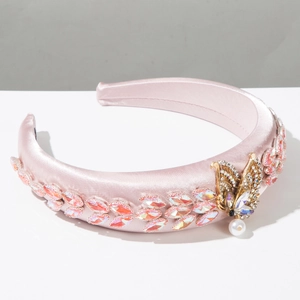 Detailed view of pink satin headband with crystal leaves and golden butterfly pendant