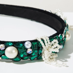 Detailed close-up of Baroque velvet headband with emerald crystals and hanging pearl fringe