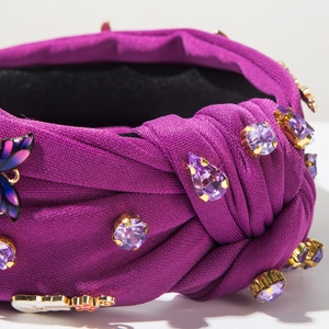 Gros plan du serre-tête noué violet avec strass et détail de papillon en émail