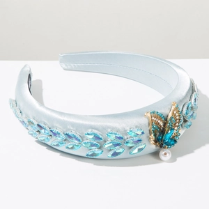 Detail of light blue satin headband with leaf-shaped gems and gold butterfly pearl charm