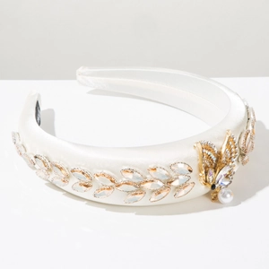 Detail of white satin headband with champagne crystals and golden butterfly charm